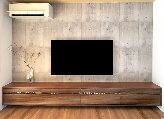 コンクリート調の壁に設置された一関市T.K様のテレビボードと壁掛けテレビ(近新)