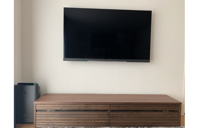 空気清浄機が横に設置された大川家具のテレビボードと壁掛けテレビ(太陽家具)